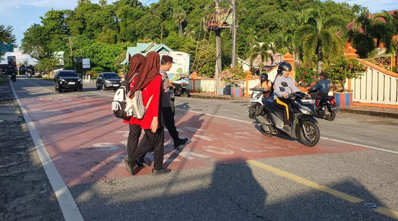 Personel Polsek Tapaktuan Humanis Jaga Kelancaran Lalu Lintas Pagi, Bantu Anak Sekolah Menyeberang Jalan